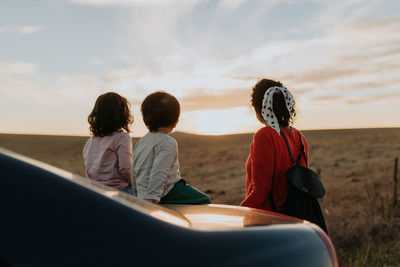 Mother with children looking at sunset