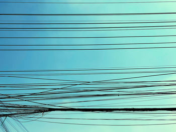 Close-up of power lines against blue sky