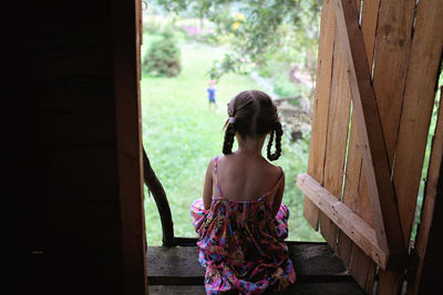 Rear view of woman standing by window