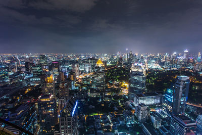 Illuminated cityscape against sky at night