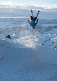 Man skiing on snowcapped mountain against sky