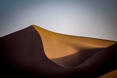 Low angle view of sand against clear sky