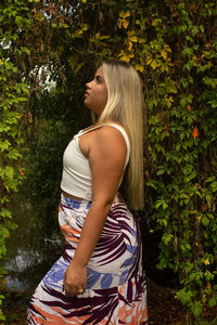 Side view of woman standing against plants