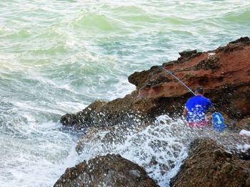 High angle view of man with son fishing by sea