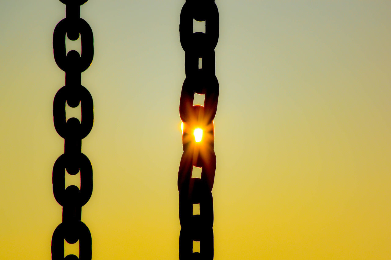 CLOSE-UP OF ILLUMINATED LAMP AGAINST ORANGE SKY