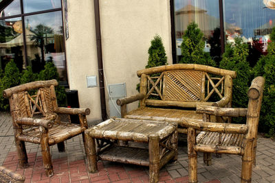 Empty chairs and tables against building