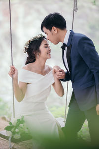 Groom kisses his bride on forehead