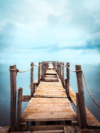 Wooden pier on sea against sky