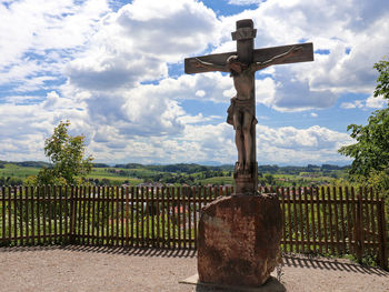 Cross on cemetery against sky