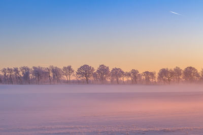 Snow covered landscape against clear sky