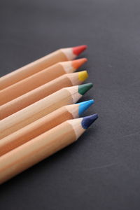 High angle view of wooden colored pencils on blackboard
