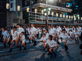 People sitting on street in city at night