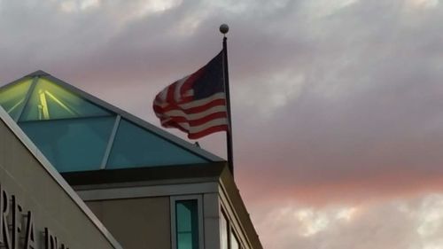 Low angle view of flags against cloudy sky