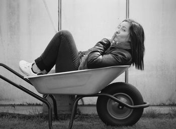 Side view of young woman sitting on floor