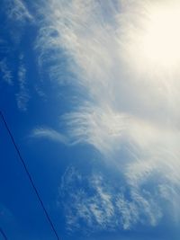 Low angle view of power lines against blue sky