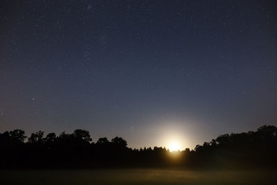 Scenic view of silhouette trees against sky at night