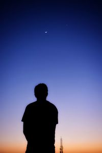 Silhouette man standing against blue sky at sunset