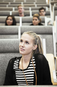 Close up of beautiful young woman sitting in auditorium