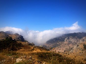 Scenic view of mountains against cloudy sky