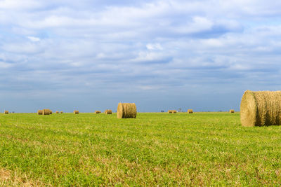 Hay bales on field against sky