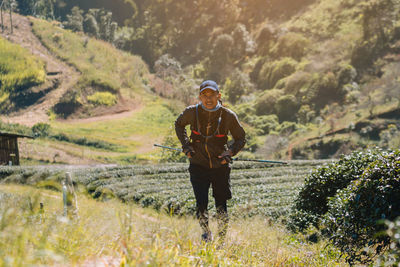 Full length portrait of man standing on landscape