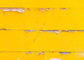 Full frame shot of yellow wood plank wall peeling