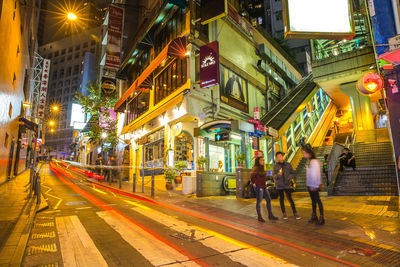 People walking on illuminated street at night