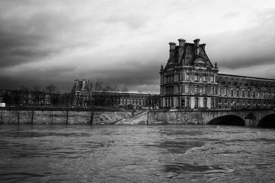 Arch bridge over river against buildings