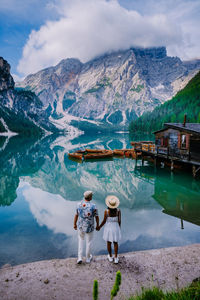 Rear view of people on lake against mountains