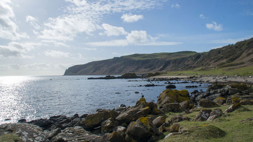 Scenic view of sea and mountains against sky