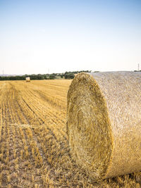 Hay bales on field against sky