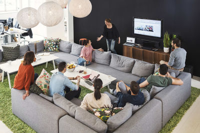 Businesswoman giving presentation to colleagues in office lobby