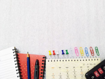 High angle view of multi colored pencils against white background