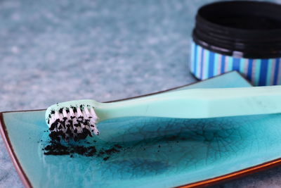 Close-up of toothbrush in tray by bottle on table