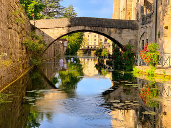 Arch bridge over canal amidst buildings