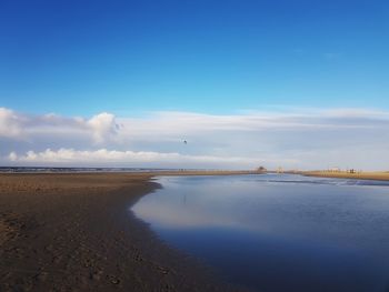 Scenic view of beach against blue sky