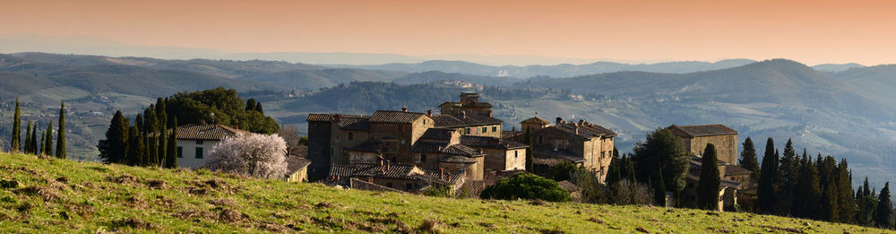 Panoramic view of buildings on mountains against sky during sunset