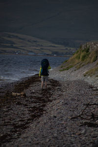 Rear view of man walking at beach