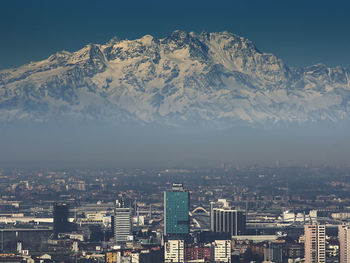 Aerial view of cityscape and mountains against sky