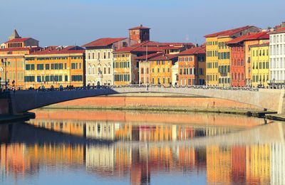 Italy, city centre of pisa, arno river reflection.