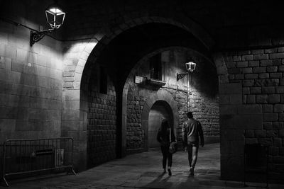 Digital composite image of woman standing against illuminated wall