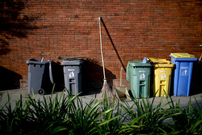Garbage bin against brick wall