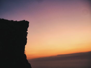 Scenic view of silhouette land against clear sky during sunset