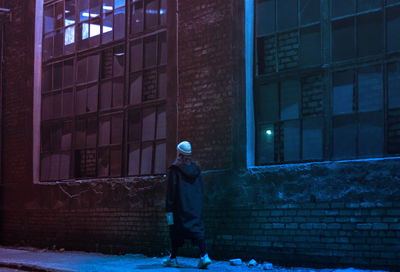 Man in front of illuminated building at night during winter