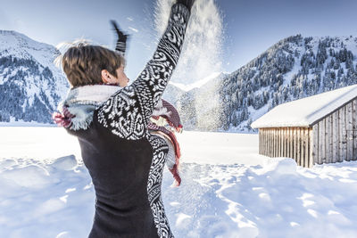 Woman playing with snow on field