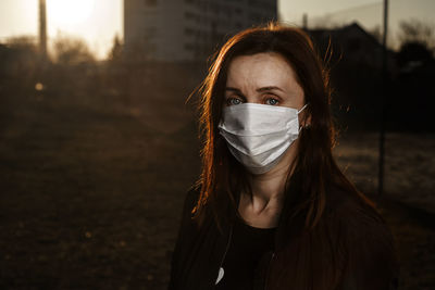 Portrait of young woman standing in city