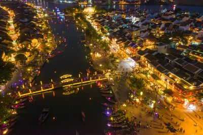 High angle view of illuminated street amidst buildings at night