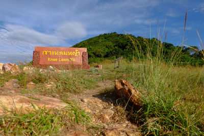 Information sign on field against sky