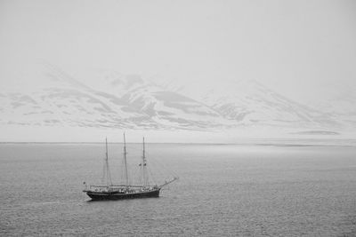 Sailboat in sea against sky during winter
