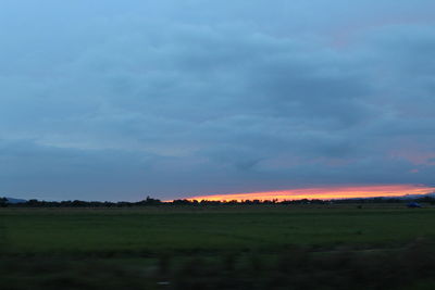 Scenic view of field against cloudy sky